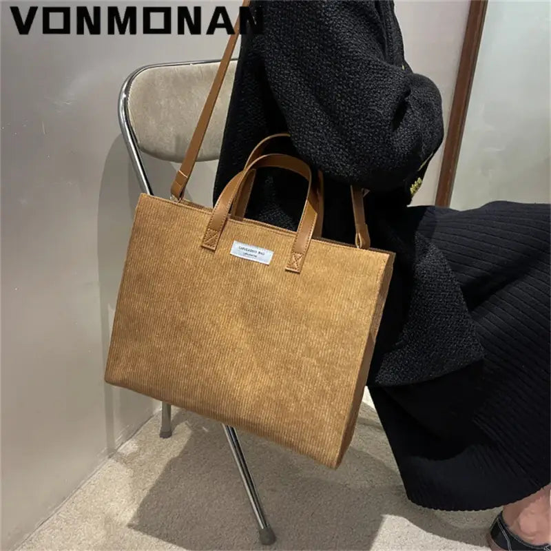 a woman sitting on a chair holding a brown bag