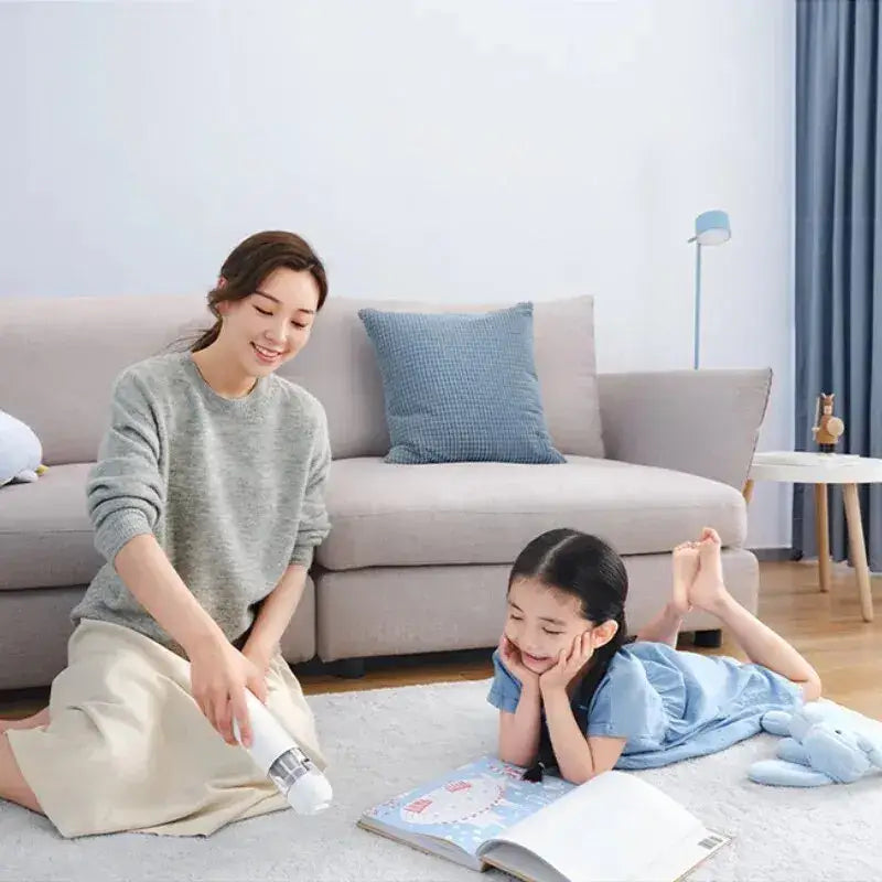a woman and child sitting on the floor reading books