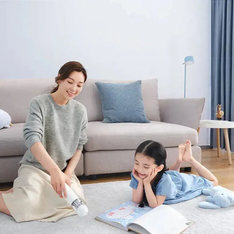 A woman and child sitting on the floor reading books