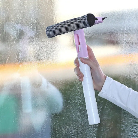 a woman is cleaning the window with a spray gun