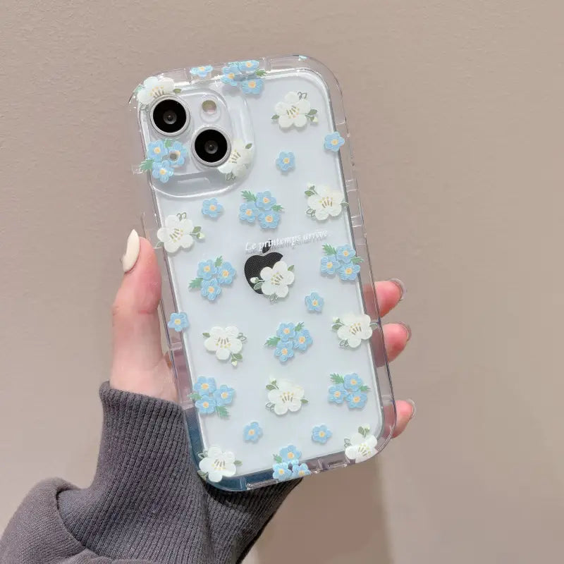 a woman holding a clear case with blue flowers on it