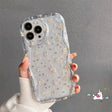 A woman holding a clear case with flowers on it