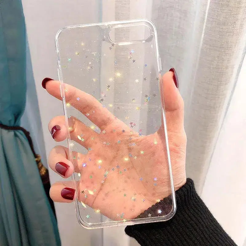 a woman holding a clear phone case with glitter
