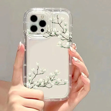 A woman holding a clear phone case with white flowers on it