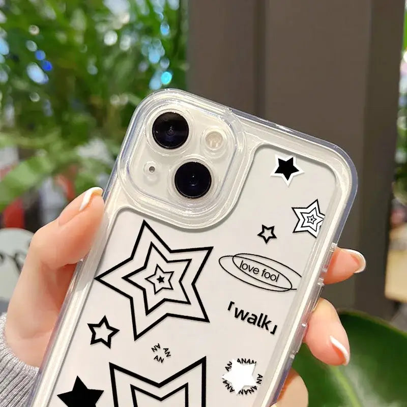 a woman holding a clear phone case with black stars on it