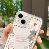 a woman holding a clear phone case with flowers on it