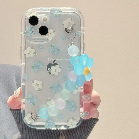 A woman holding a clear phone case with blue and white flowers