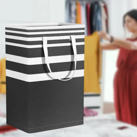 a woman in a red dress is holding a black and white striped shopping bag