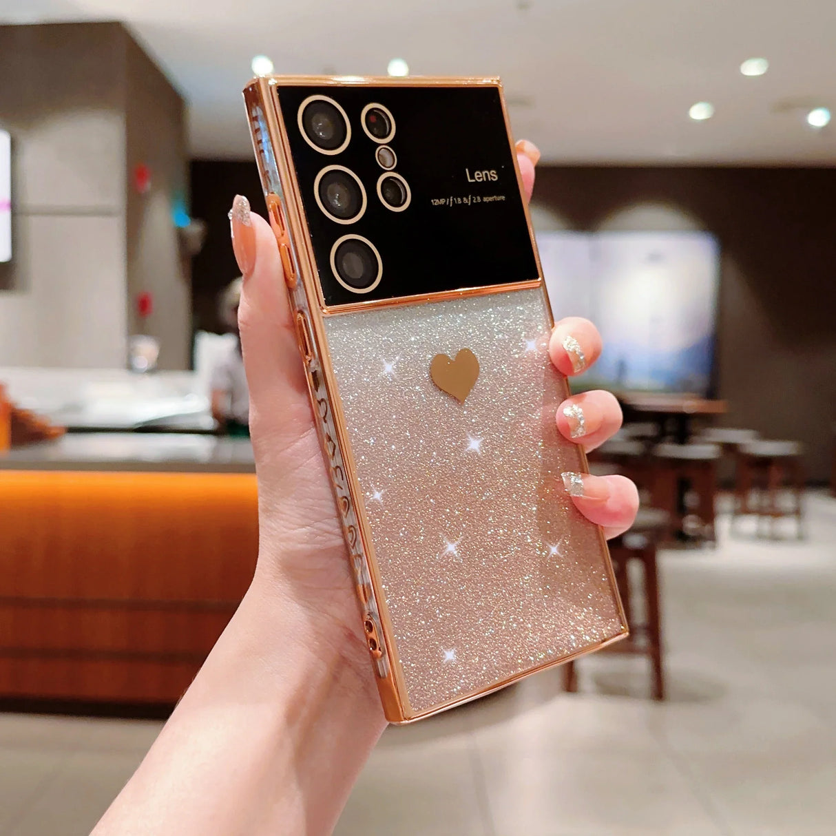 a woman holding up a gold case with a heart on it