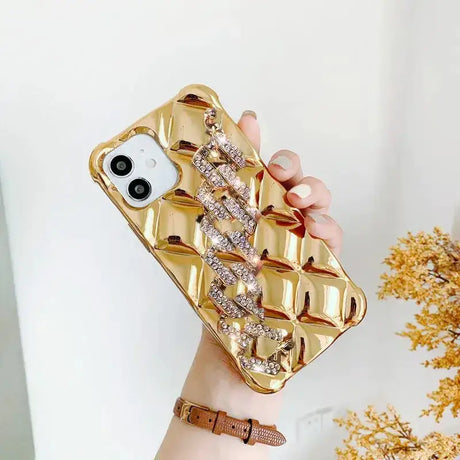 A woman holding a gold phone case with a diamond bow