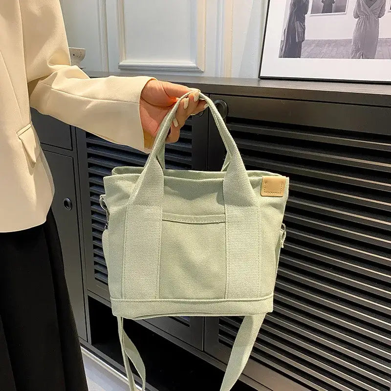 a woman holding a green bag in front of a black and white photo