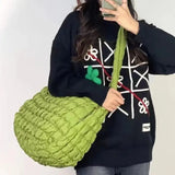 a woman holding a green bag while looking at her phone