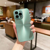 a woman holding up a green iphone case