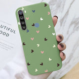 a woman holding a green phone case with hearts on it
