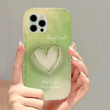 a woman holding a green phone case with a heart