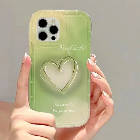 A woman holding a green phone case with a heart