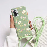 a woman holding a green phone case with flowers on it