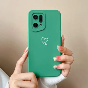 A woman holding a green phone case with a heart drawn on it