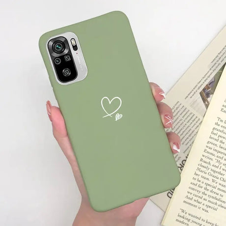 a woman holding a green phone case with a heart on it