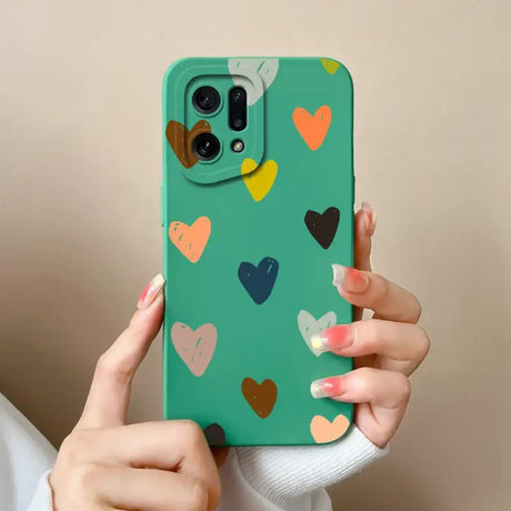 A woman holding a green phone case with hearts on it