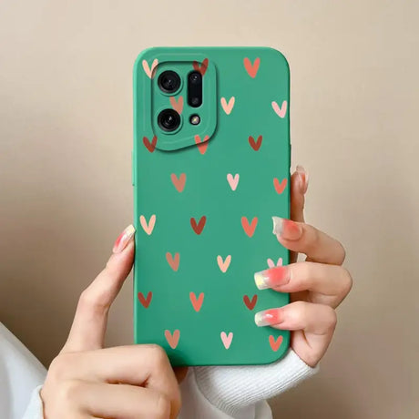 A woman holding a green phone case with hearts on it