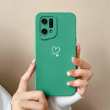 A woman holding a green phone case with a heart drawn on it