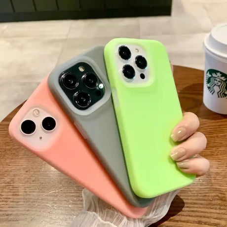 a woman holding a green and pink iphone case