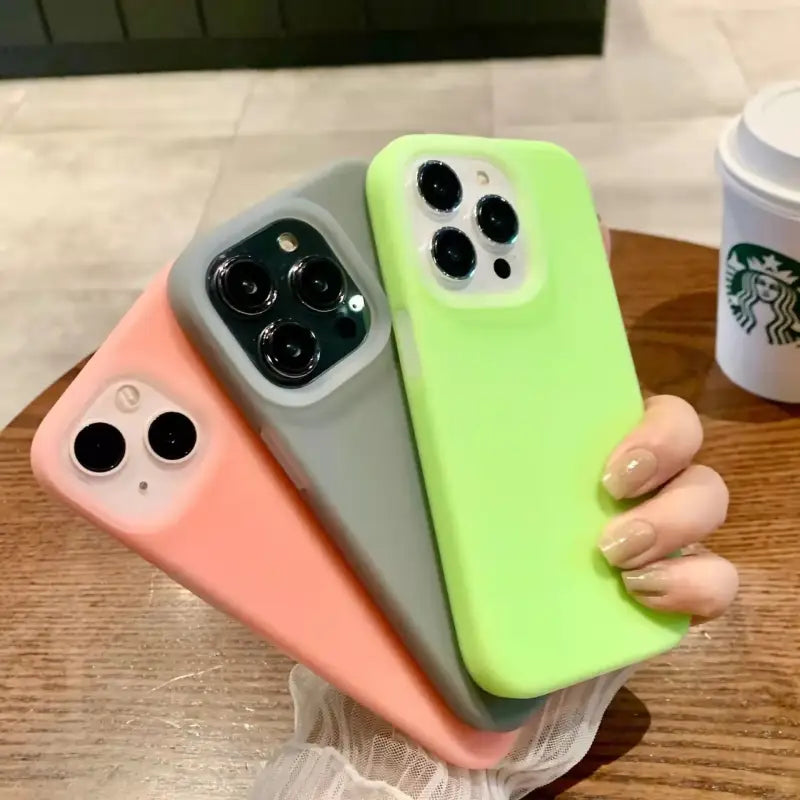 A woman holding a green and pink iphone case