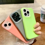 A woman holding a green and pink iphone case