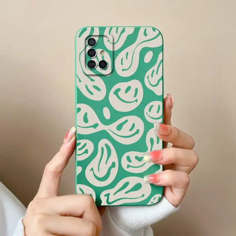 a woman holding a green and white phone case