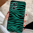 A woman holding a green zebra print phone case