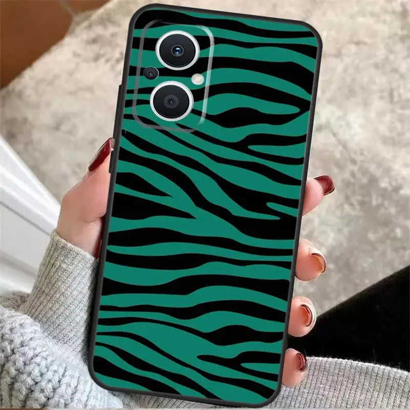 a woman holding a green zebra print phone case