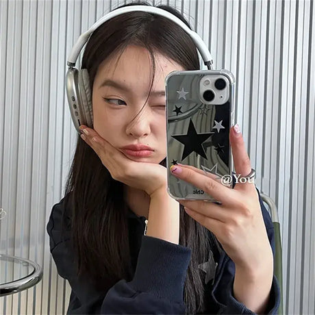 A woman wearing headphones and holding a phone