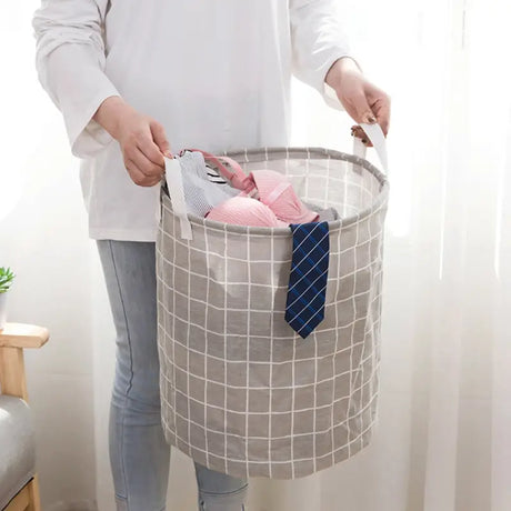 a woman holding a basket with clothes inside