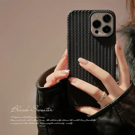 a woman holding a black iphone case