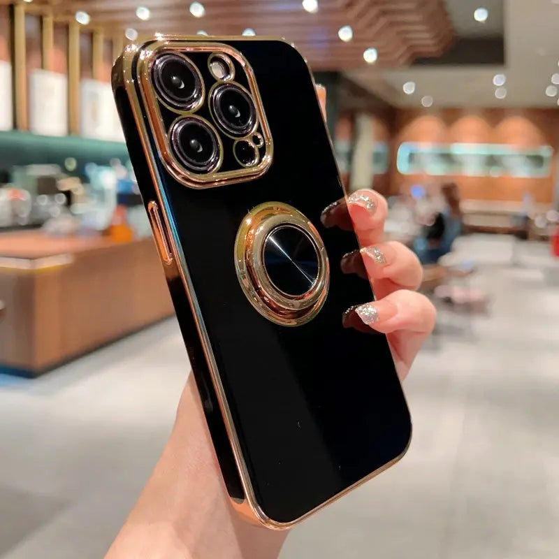 a woman holding a black iphone case with a gold ring