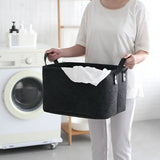 a woman holding a black laundry bag