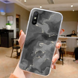 a woman holding up a black marble phone case