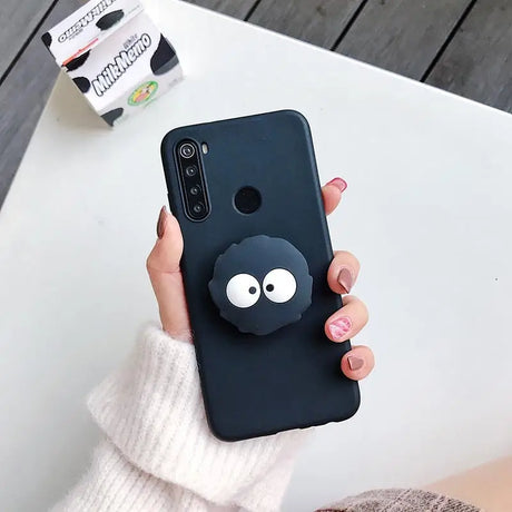 a woman holding a black phone case with a black cat on it