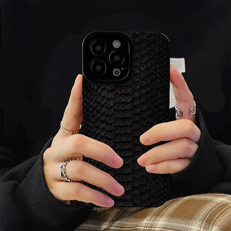 a woman holding a black phone case with a black snake skin