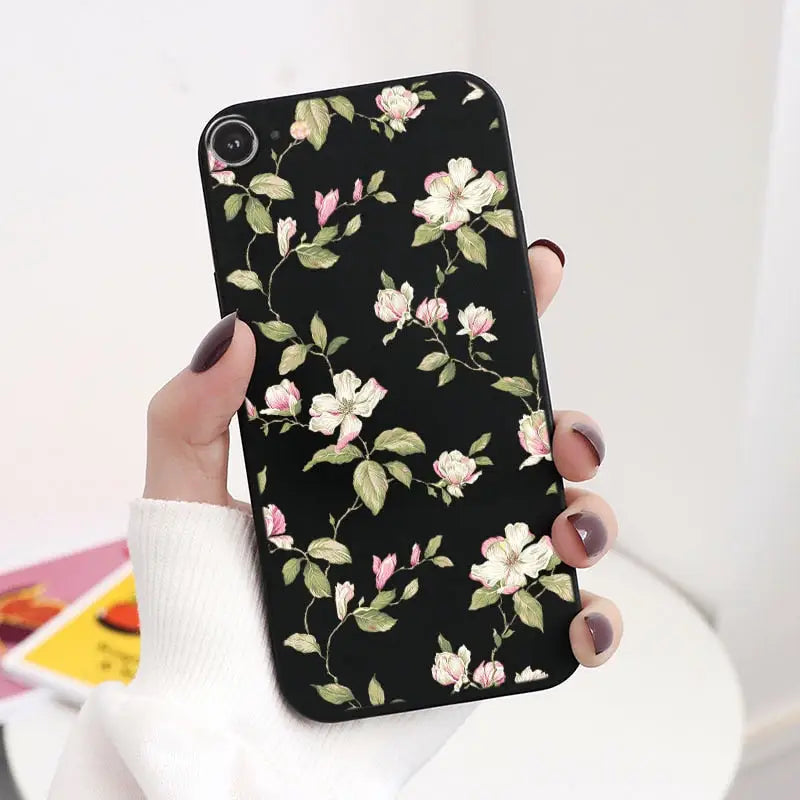 a woman holding a black phone case with pink flowers