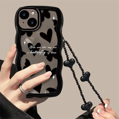 a woman holding a black phone case with a chain attached to it