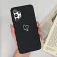 a woman holding a black phone case with a heart on it