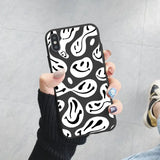 a woman holding up a black and white phone case