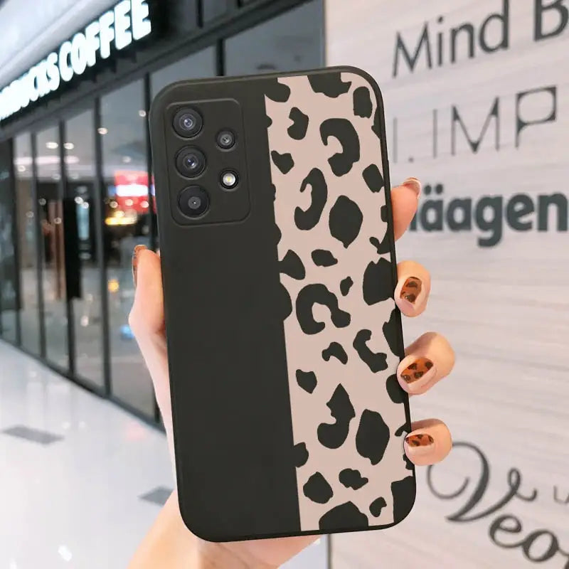 a woman holding up a black and white phone case