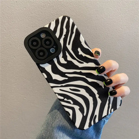 a woman holding a black and white zebra print phone case