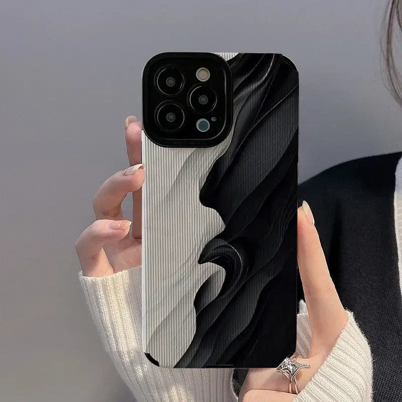 a woman holding a black and white phone case