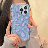 a woman holding up a blue camouflage iphone case