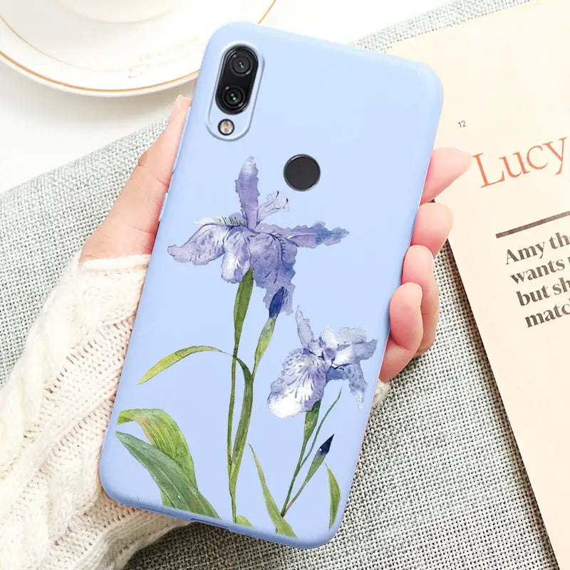 a woman holding a blue flower phone case