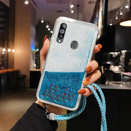 a woman holding a blue glitter phone case